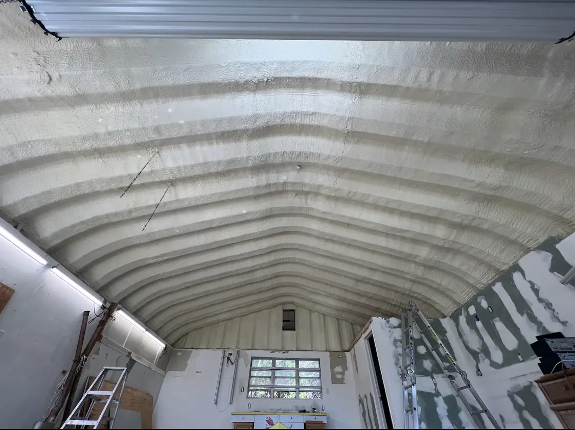 Spray polyurethane foam applied to the underside of a metal roof deck in Seymour